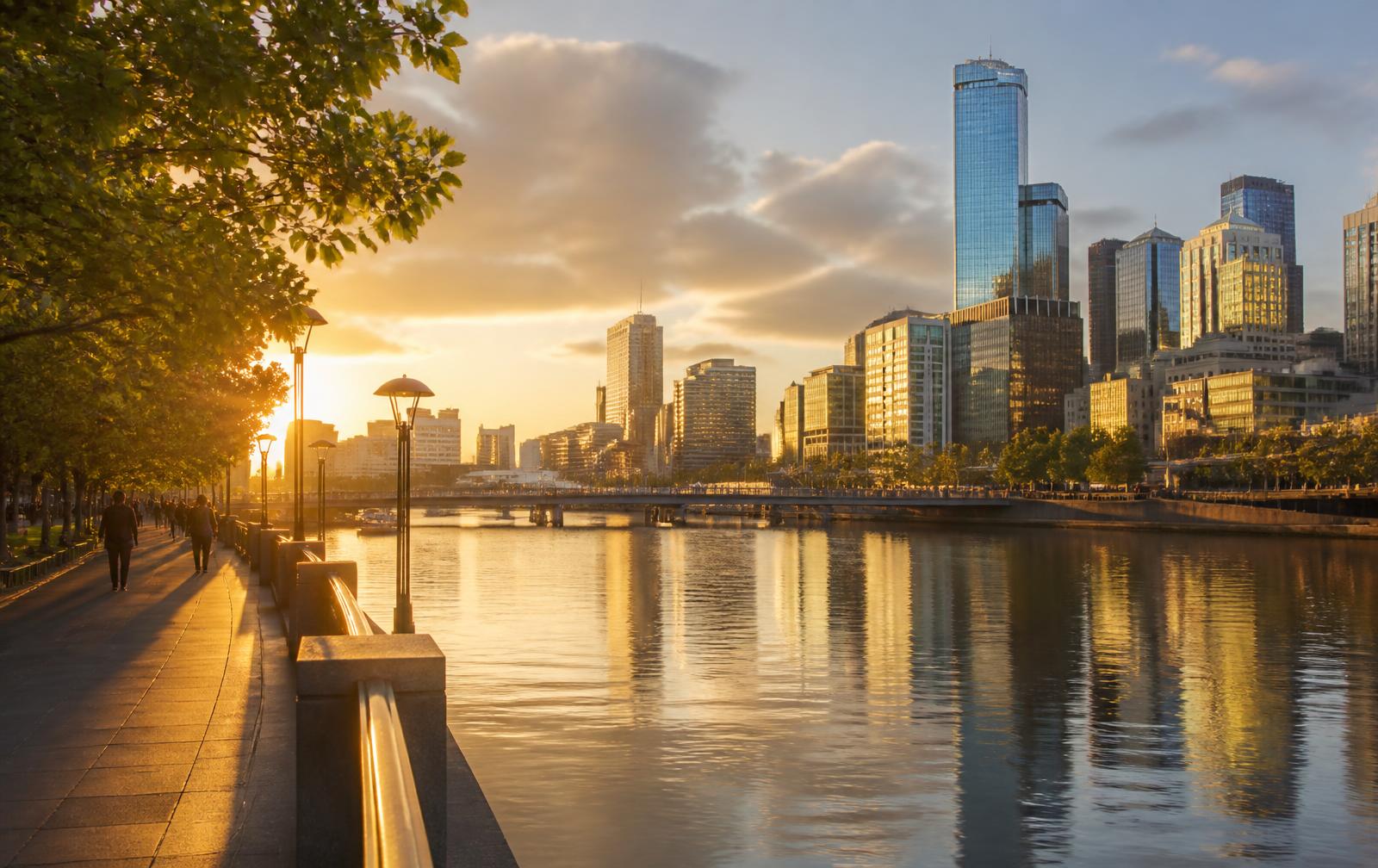 Southbank promenade beside the Yarra River with the Melbourne skyline at golden hour